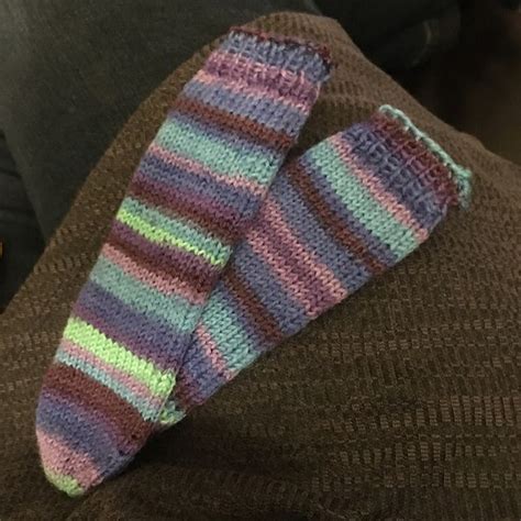 A Pair Of Striped Socks Sitting On Top Of A Persons Lap In Front Of A