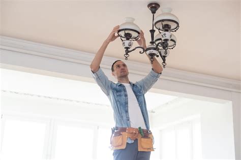 Premium Photo An Electrician Fixing Wires Installing Light On The Ceiling