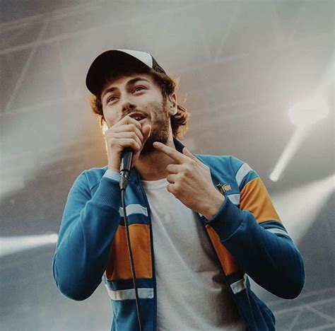 A Man Holding A Microphone Up To His Mouth