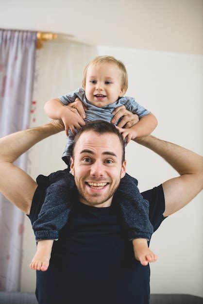 Gl Cklicher Vater Mit Seinem Sohn Auf Den Schultern Kostenlose Foto