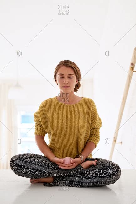 Pretty Woman Sitting Cross Legged On Floor Meditating Stock Photo Offset
