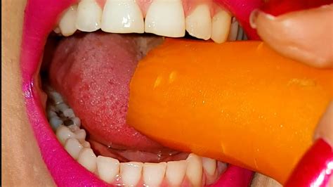 Girl With Really Strong Teeth Bites And Crushes A Carrot Into Pulpthen Shows The Pulp On Her