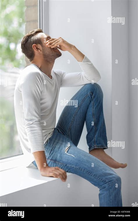 Handsome Shy Man Close Face With Hand Sitting On Window Sill Stock