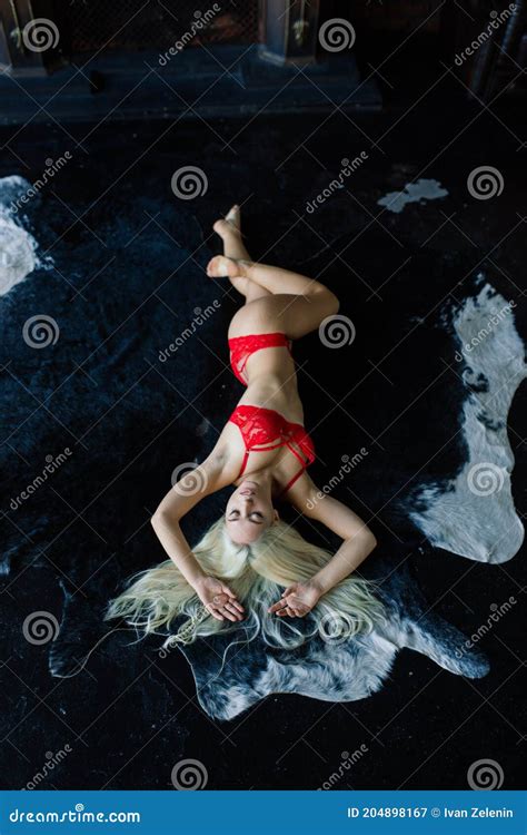 Fashion Model With Blond Hair Posing In Bedroom Wearing Red Lingerie