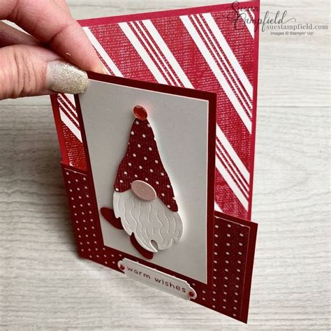 A Hand Holding Up A Card With A Christmas Hat On It