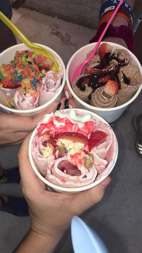 Three People Holding Up Bowls With Different Types Of Ice Creams In