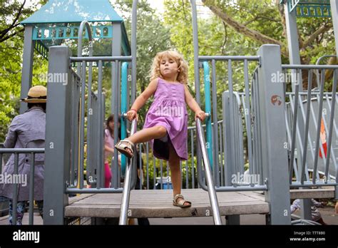 little girl on playground with leg up, ready to move Stock Photo - Alamy