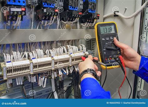 Electrician With Multimeter In Hands Measures Voltage In The Electrical