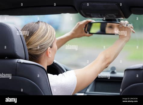 Woman Adjusting Rearview Mirror In The Car Stock Photo Alamy