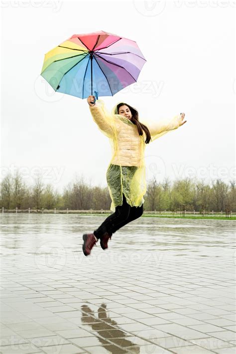 Beautiful Brunette Woman Holding Colorful Umbrella Out In The Rain