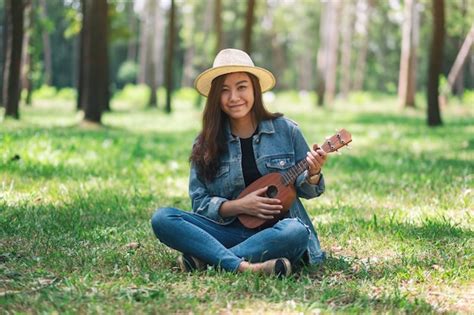 Premium Photo A Beautiful Asian Woman Sitting And Playing Ukulele In