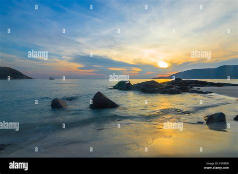 Beach rock and sunrise background Stock Photo - Alamy