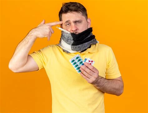 Pâle jeune homme slave malade blonde couvrant la bouche avec un foulard Photo Gratuite