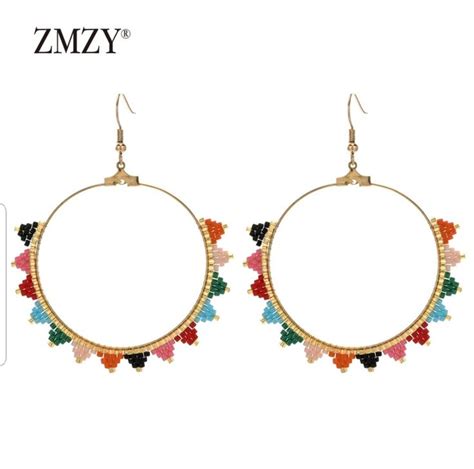 A Pair Of Hoop Earrings With Multicolored Beads On The Front And Back Of It