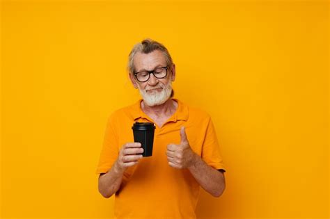 Premium Photo Senior Greyhaired Man In A Yellow Tshirt A Glass With A