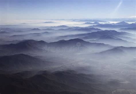 Clouds Linger Over Hills Stretching Into Distance As Photographed From