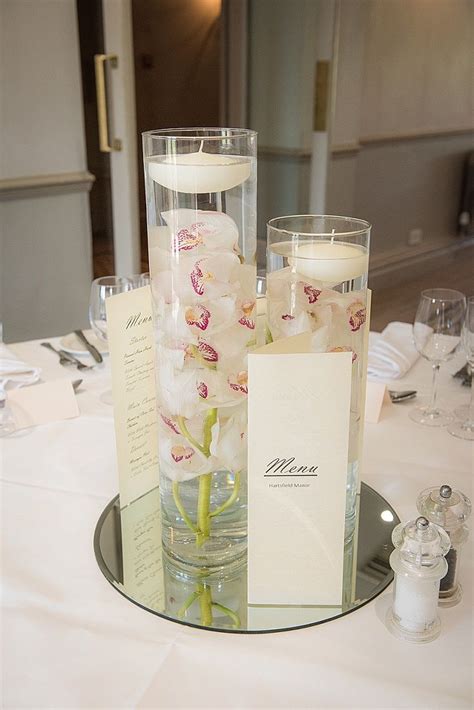 White Cymbidium Orchid In Cylinder Vase With Floating Candle Centr