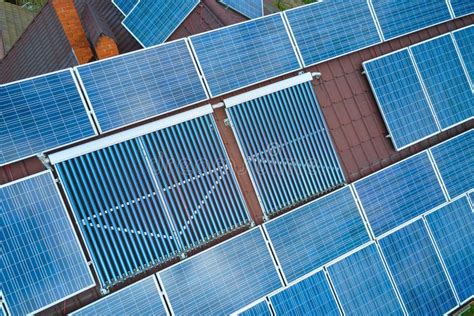 Building Roof With Rows Of Blue Photovoltaic Panels And Vacuum Air