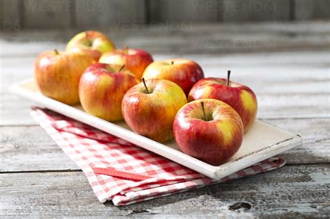 Bowl With Eight Organic Apples On Kitchen Towel And Wooden Table Stock