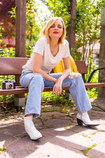 Touriste blonde en vacances d été assise sur un banc dans un parc Photo Premium