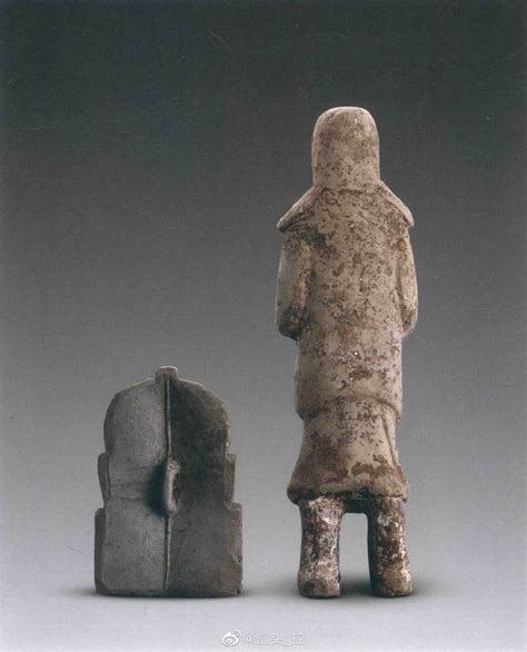 An Old Statue Next To A Small Stone Object In The Shape Of A Human Head