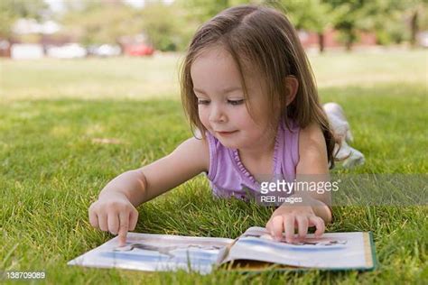 Girl Lying On Grass And Reading A Book Photos And Premium High Res