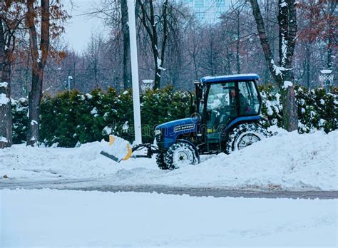 Blue Tractor Cleans City Streets And Roads After Heavy Snowfall