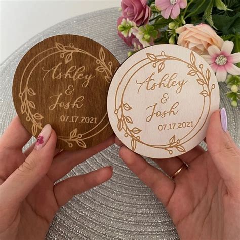 Two Wooden Coasters With Wedding Date Printed On Them One Is Holding