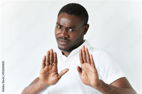 Isolated Shot Of Grumpy African Male Showing Stop Sign With His Open