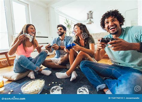 Friends Play Video Games Together At Home Having Fun Stock Photo