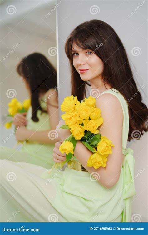 Beautiful Gentle Young Woman Brunette With A Bouquet Of Yellow Tulips