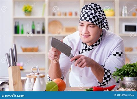 The Young Male Cook Working In The Kitchen Stock Photo Image Of Knife