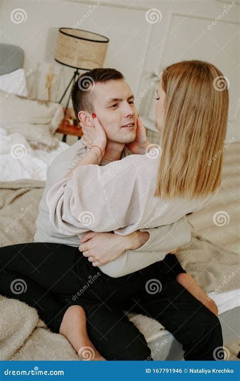 Close Up Portrait Of A Beautiful Young Couple Hugs In Bed At Home Stock