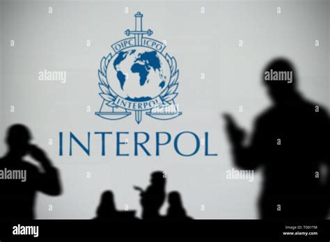 The Interpol logo is seen on an LED screen in the background while a ...