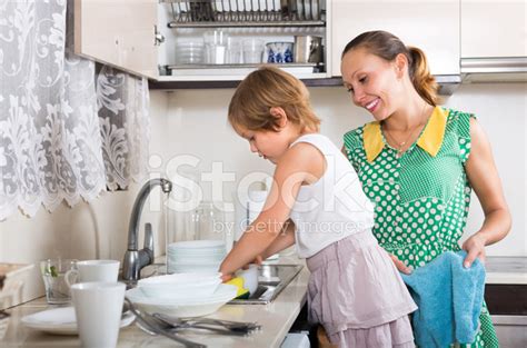 Chica Ayudando A Lavar Los Platos Madre Fotografías De Stock