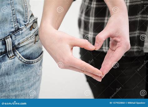 Two Girls In Jeans Hold Hands Close Up White Background Homosexual