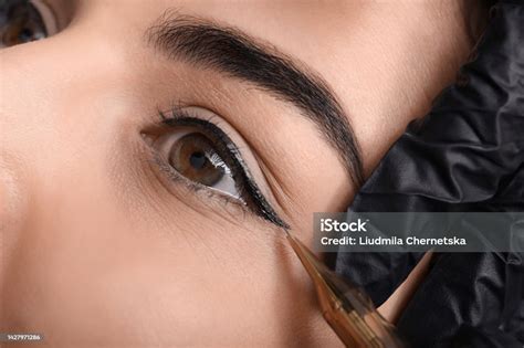 Young Woman Undergoing Procedure Of Permanent Eye Makeup In Tattoo