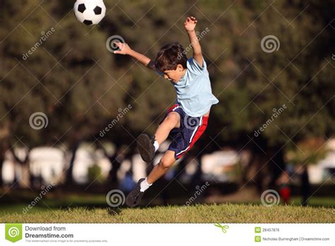 Menino Novo Que Retrocede Uma Bola De Futebol No Parque Foto De Stock