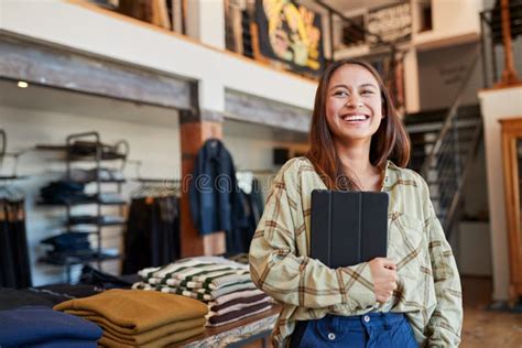 Portrait Of Female Owner Of Fashion Store Using Digital Tablet To Check