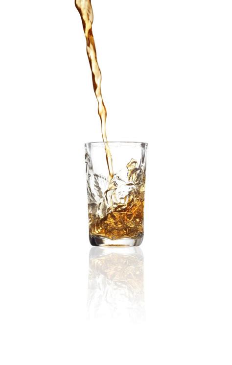 Pouring Whiskey Into Shot Glass On White Background Stock Photo