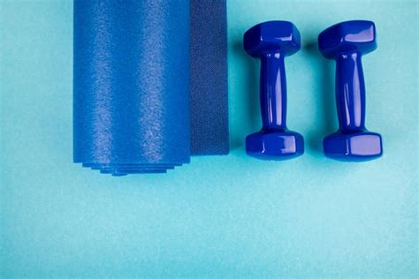 Premium Photo Top View Of Blue Dumbbells And Fitness Mat On Blue