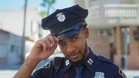 A Confident African American Police Officer Saluting Outdoors In An