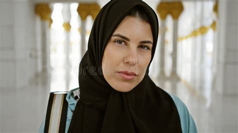 Portrait Of A Contemplative Adult Hispanic Woman Wearing A Hijab At An