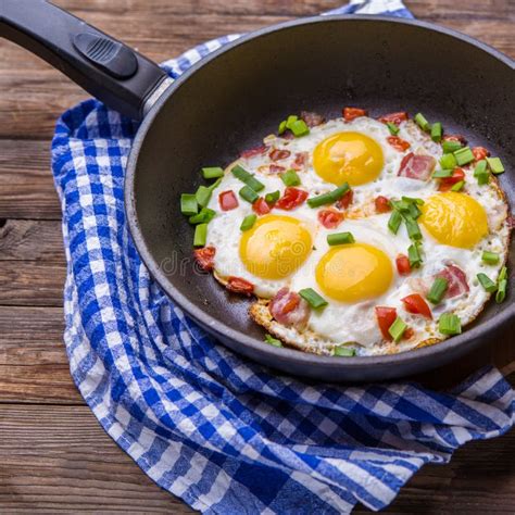 Fried Eggs In Pan With Tomatoes And Green Fresh Onion Stock Image