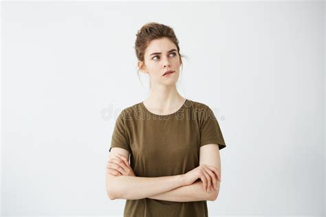 Beautiful Shy Young Girl With Hair Bun Thinking Biting Lip Over White