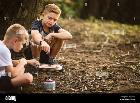 Boys cooking on camping stove outdoors Stock Photo - Alamy