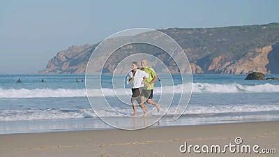 Couple Mature Heureux Courant Pieds Nus Sur La Plage De Sable Banque De