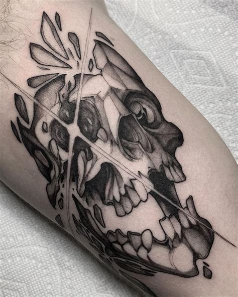 A Black And White Photo Of A Skull Tattoo On The Arm With Geometric