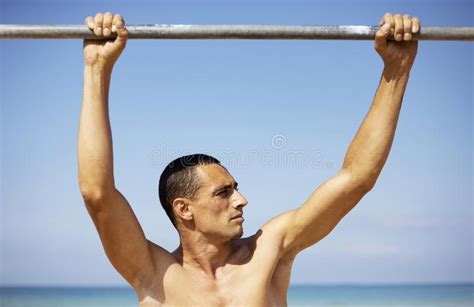 A Male Athlete With A Naked Torso Is Training On A Horizontal Bar Stock Photo Image Of