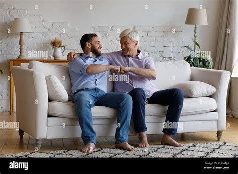 Happy Mature Grey Haired Dad Congratulating Adult Son On Success Stock